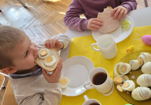 Chłopiec je kanapkę z jajkiem