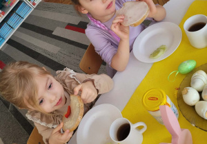 Dziewczynki jedzą kanapki z jajkiem i warzywami