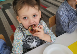 Dziewczynka je babeczkę