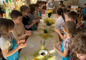 Dzieci przy stole robią kulki z ciasta