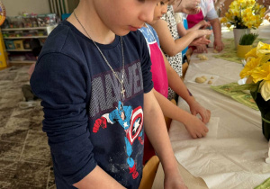 Chłopiec robi kulki z ciasta drożdżowego