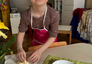 Dziewczynka przyczepia uszy z ciasta królikowi