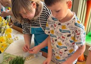 Chłopiec łączy elementy ciasta tworząc królika