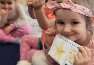 dzieci pokazuja plansze z ćwiczeniem