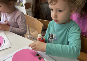 Chłopiec przykleja zieloną bibułę