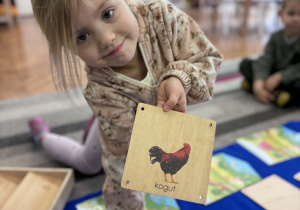 Dziewcyznka pokazuje kurę