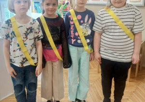 Dzieci stoją z szarfami żółtymi