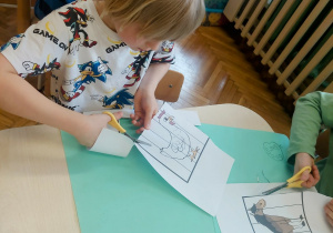 Chłopiec wycina puzzle przy stoliku