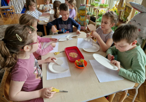 Dzieci tną talerzyki papierowe po linii