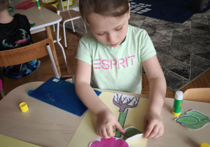 Dziewczynka przykleja liść