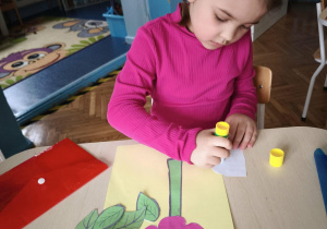 Dziewczynka smaruje klejem liść