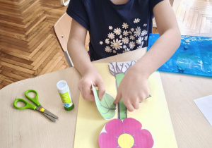 Dziewczynka przykleja do łodygi liść