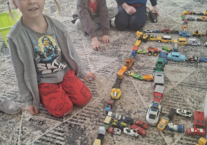 Chłopcy układają autka