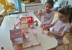 Dziewczynki bawią się domkiem