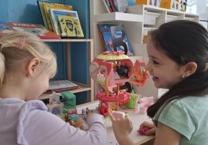 Dziewczynki bawią się małym domkiem