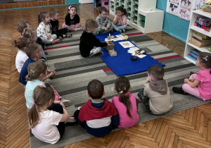 Dzieci siedzą na dywanie