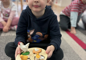 Chłopiec pokazuje drewniany model rozwoju kury