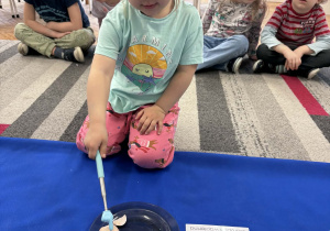 Dziewczynka wskazuje skorupkę od jajka