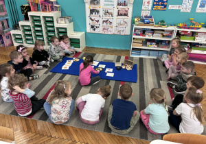 Dzieci siedza na dywanie przed jajkami