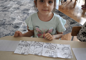 Dziewczynka uklada historyjkę obrazkową