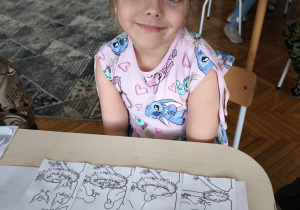 Dziewczynka zułożoną historyjką obrazkową o ptaku w gnieździe