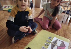 Chłopiec z ułożonymi czterema ptakami pod karmnikiem