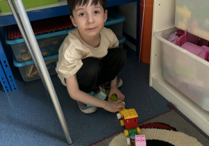 Chłopiec bawi się pociągiem z klocków duplo