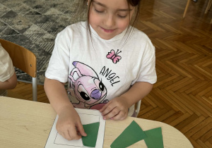 Dziewczynka przy stoliku układa z części kwadrat