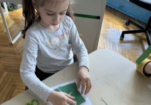 Dziewczynka uklada z części kwadrat