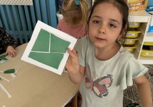 Dziewczynka pokazuje ułożony kwadrat z części