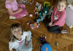 Dziewczynki bawią się domkami dla lalek