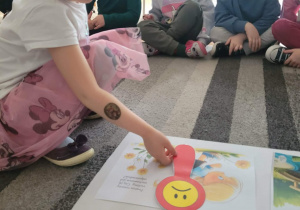 Dziewczynka uklada znaczek smutnej buzi