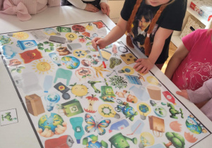 Dziewczynka szuka na planszy kranu z wodą