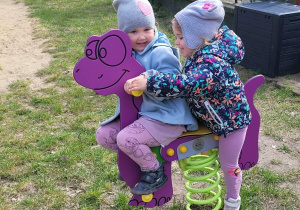 Dziewczynki na bujaku dinozaura