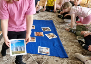 Dziewczynka poakzuje obrazek z silosami