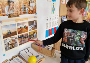 Chłopiec wskazuje obrazek traktora na polu