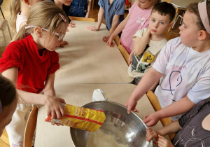 Dziewczynka wsypuje mąkę do miski