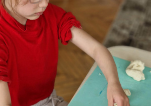 Dziewczynka zaplata chałkę z masy solnej