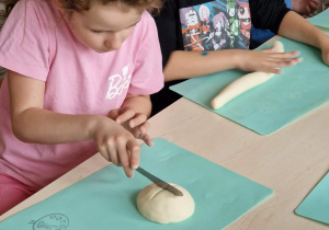 Dziewczynka lepi bułkę z masy solnej