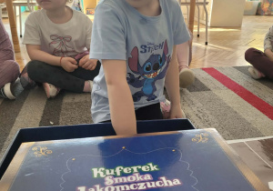 Dziewczynka wkłada rękę do magicznego pudełka