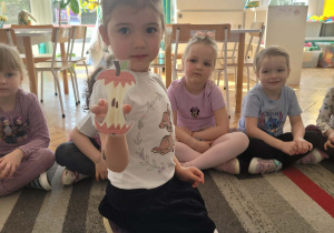 Dziewczynka poakzuje obrazek ogryzka po jabłku