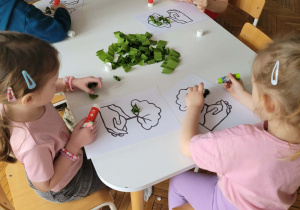 Dzieci przy stoliku robią kulki z bibuły