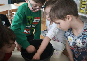 Chłopcy nabierają ziemię do doniczek