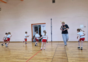 Dzieci biegają po sali gimnastycznej