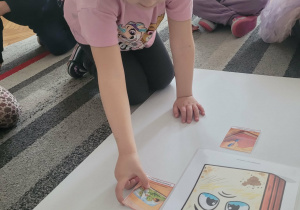 Dziewczynka układa obrazek do smutnej książki mówiący o wyrywaniu kartek