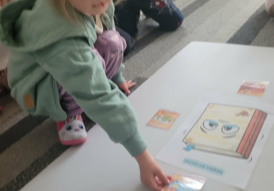 Dziewczynka układa obrazek do smutnej książki mówiący o rzuceniu i deptaniu książek