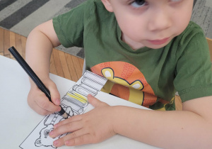 Chłopiec koloruje zakładkę do książki