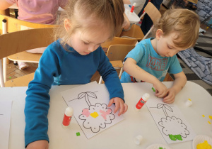 Chłopiec z dziewczynką wyklejają środek kwiatka