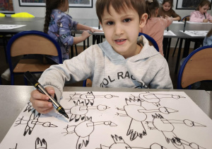 Chłopiec z narysowanymi bocianami czarnym mazakiem