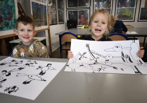 Chłopcy pokazują namalowane czarne bociany